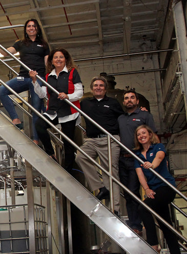 a group of people posing for a photo in a plant