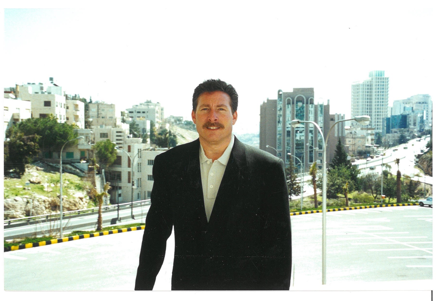 a person (Jay Glauberman) in a suit standing on a street