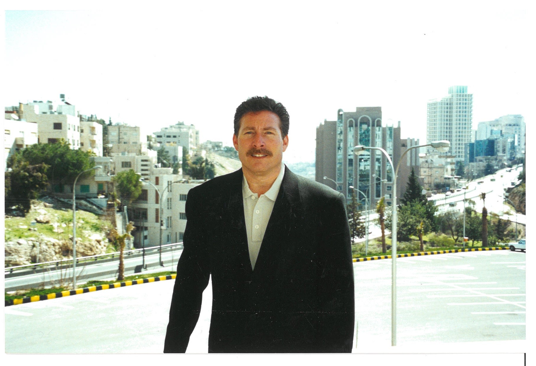 a person (Jay Glauberman) in a suit standing on a street 